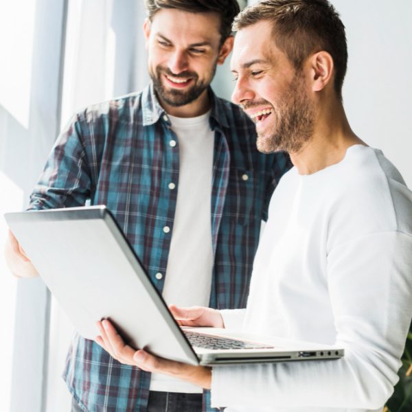 close-up-two-smiling-young-businessmen-using-laptop (1)